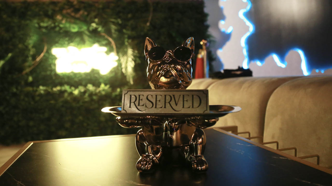 Neon 'Reserved' sign marking a VIP booth at District385