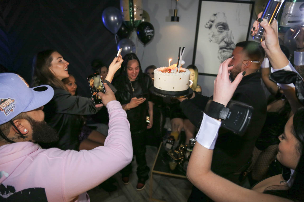 A sparkler-topped birthday cake carried through the room at District385