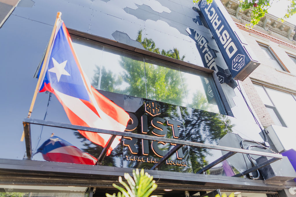 The District385 sign above the entrance with the Puerto Rican flag flying