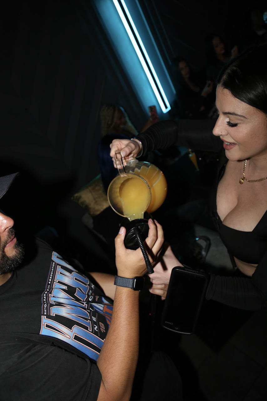 A host pouring champagne at a VIP booth at District385