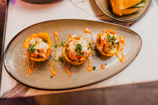 Tostone cups topped with shrimp and spicy sauce at District385