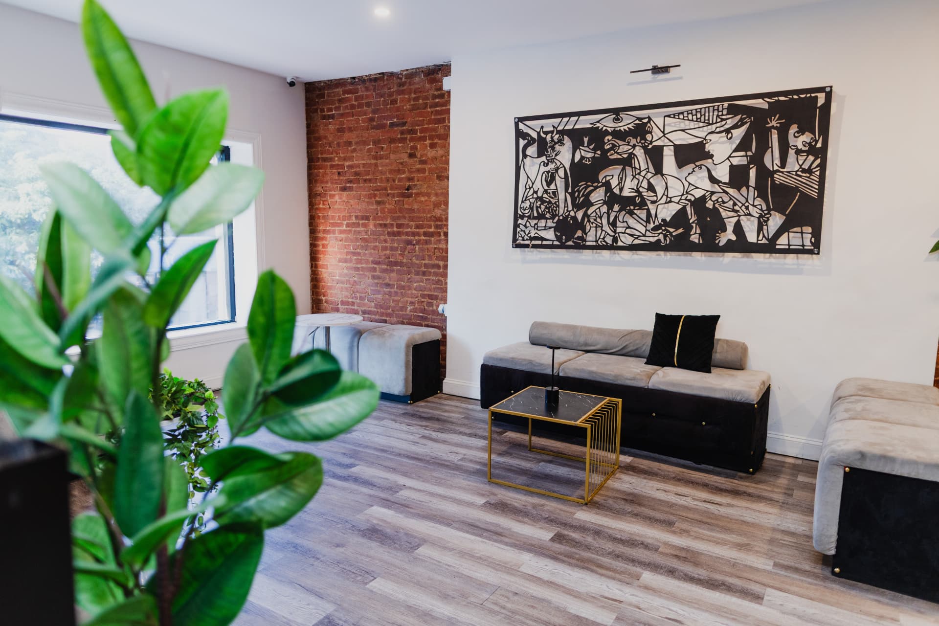 Exposed brick wall and black-and-white artwork over lounge seating at District385