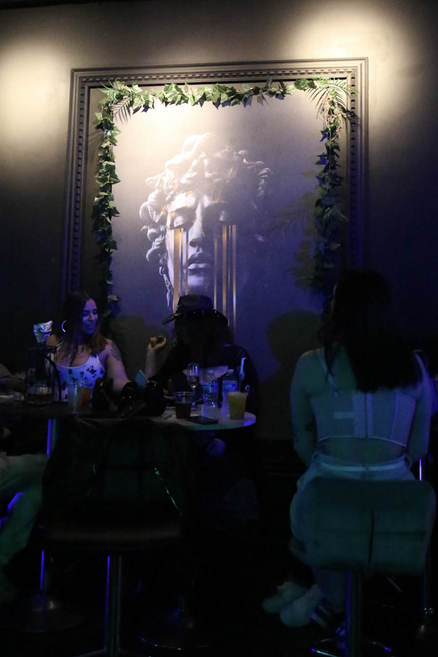 Guests seated beneath the Medusa portrait in the District385 lounge