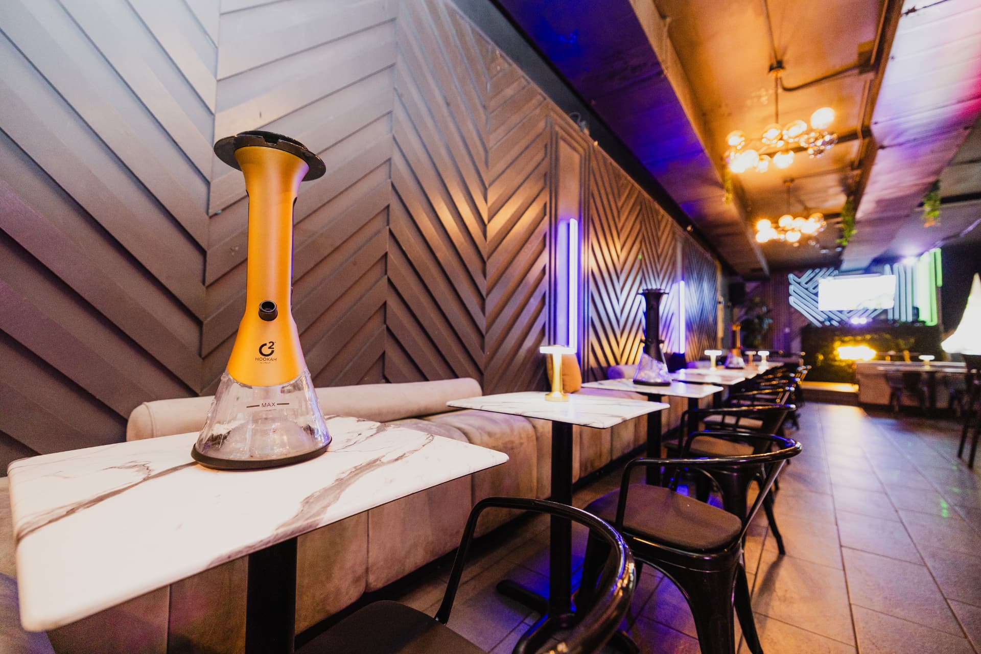 Marble tables set with hookahs along the District385 lounge banquette